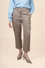 Pantalón de tiro alto color tostado, con diseño de pierna recta y largo al tobillo, con bolsillos laterales y cierre frontal con botón y cremallera.