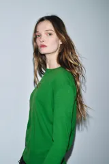 Jersey de punto liso color verde, con cuello redondo y manga larga. Confeccionado en lana suave.