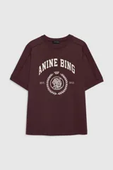 Remera Anine Bing modelo Jaylin Collegiate de corte recto y ligeramente oversize, confeccionada en algodón blanco. Presenta cuello redondo y un estampado central en tono bordó con un emblema de cabeza de tigre, corona de laurel y las inscripciones del logo arqueado y las ciudades de Los Ángeles y París.