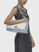Cartera tipo shoulder bag de Marc Jacobs en color plateado metalizado, con diseño estructurado, solapa frontal y cierre metálico giratorio.