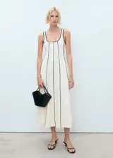 Vestido midi de algodón con diseño sin mangas, cuello escotado y tirantes anchos. Presenta un corte recto con costuras verticales en relieve que crean un efecto de rayas en contraste.
