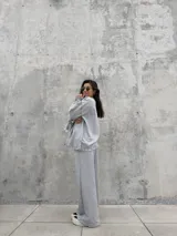 Pantalón de calce holgado color gris, con cintura elástica en contraste color negro, bolsillos laterales y costuras overlock expuestas a lo largo de las piernas.