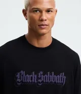 Remera negra de algodón con corte comfort, cuello redondo y manga corta. Presenta un estampado frontal con el logo de la banda Black Sabbath en color violeta.