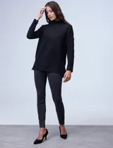 Polera negra de tejido soft con cuello alto y mangas largas con aplique de botones.