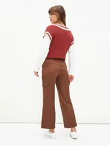 Pantalón cargo de corte recto y tiro medio, color marrón, con bolsillos laterales con solapa y cierre frontal con botón y cremallera.