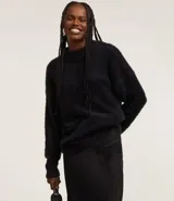 Suéter de punto color crema con cuello redondo y mangas largas ajustadas. Modelo slim alargado con efecto de pelitos.