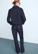 Jeans de corte recto y tiro medio, confeccionados en tejido de algodón estilo vaquero en tono azul oscuro. Presentan diseño de cinco bolsillos, cierre de botón con cremallera, trabillas para cinturón y aberturas laterales en el bajo.