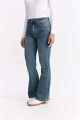 Jean de corte oxford con tiro alto, ajustado hasta la rodilla y con apertura amplia en el bajo. Confeccionado en denim negro con cierre frontal de botón y cremallera.