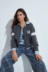 Campera de punto tipo cardigan en color bordó, con cierre frontal, cuello redondo y diseño estilo universitario. Presenta el número 54 bordado en blanco en el pecho y franjas blancas en las mangas.