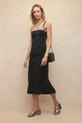 Vestido strapless largo color negro, de textura tipo lavada con cierre en la espalda y corte en la parte más baja.