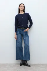 Cardigan de punto color azul marino, con cuello redondo y cierre frontal de botones marrones. Presenta un patrón de estructuras en el tejido.