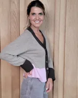 Cardigan de punto color beige, con escote en V, cierre frontal de botones y mangas largas con puños anchos acanalados.