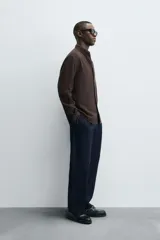 Camisa de corte regular fit confeccionada en tejido de algodón con textura de cuadrillé. Presenta cuello solapa, manga larga con puños abotonados y cierre frontal mediante botonadura.