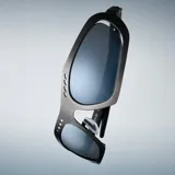 Lentes de sol envolventes con montura de acero inoxidable en acabado plateado cepillado y lentes de nylon espejadas. Presentan un diseño vanguardista con aberturas decorativas en la parte superior del marco.