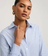 Camisa de tricolina marca Cortelle, con cuello solapa, abotonado delantero y mangas largas, con estampa de rayas en hilo teñido.