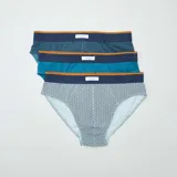 Pack de tres slips de hombre, uno azul marino con estampado geométrico, uno azul liso y uno azul con rayas horizontales y estampado geométrico.