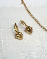 Aros abridores dorados con baño de oro 24K, con dije colgante en forma de corazón irregular con apliques texturados en el contorno.
