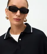 Buzo cerrado de algodón con cuello polo, mangas largas con puños ajustados y detalle de líneas contrastantes en el cuello.