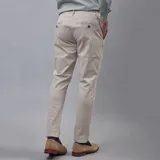 Pantalón de gabardina color azul marino, de corte ajustado y tiro medio, con cierre y botón frontal.