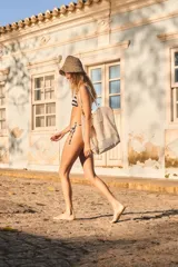 Conjunto de bikini con estampado de rayas horizontales en azul marino y blanco. El corpiño es de estilo triangular con breteles finos para atar, y la bombacha es de corte clásico con tiras laterales ajustables.