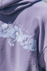 Hoodie de corte oversize color lila, con capucha ajustable mediante cordones, bolsillo frontal tipo canguro y bordado sutil en el pecho.