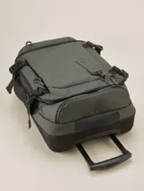 Valija gris con ruedas, manija extensible y múltiples bolsillos con cierre.