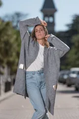 Saco gris de tejido de punto con mangas largas y apliques de cuero dorado en los laterales.