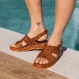 Sandalias de cuero color blanco con textura tipo reptil, plataforma marrón y hebilla metálica plateada.