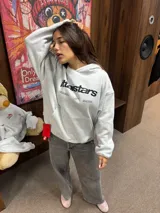Hoodie gris jaspeado con capucha, bolsillo frontal tipo canguro y estampado gráfico en el pecho con la marca ittaistars.