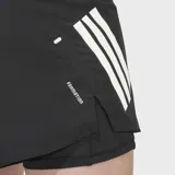 Short deportivo Adidas 2 en 1, compuesto por un short exterior de corte clásico y una calza interior ajustada. Presenta diseño en color negro con las icónicas tres bandas de la marca en tono claro sobre el lateral y logo reflectante. Incluye bolsillos laterales con cierre y tecnología Climacool para mayor transpirabilidad.