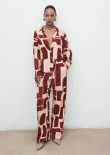 Pantalón fluido de tiro medio con estampado geométrico en tonos bordó y beige, cintura elástica con cordón ajustable, bolsillos laterales y diseño de pernera recta.