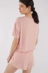 Remera de punto rib color rosa, de corte oversize, con mangas cortas y cuello redondo.