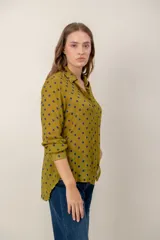 Camisa de manga larga con estampado de leopardo, cuello clásico y cierre frontal de botones. Presenta un corte holgado y puños abotonados.