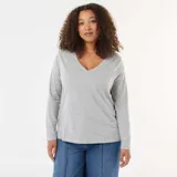 Remera de punto color gris, con cuello en V y mangas largas.