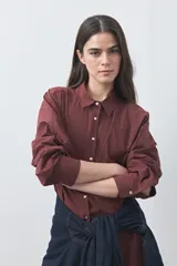 Camisa de manga larga de algodón en color blanco, con cuello clásico, cierre frontal de botones y silueta relajada.