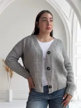 Saco de lana color gris con textura tejida y botones marrones.