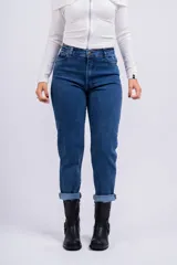 Pantalón de jean azul oscuro, corte mom, tiro alto y ruedo arremangado.