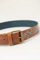 Cinturón de cuero vacuno color marrón con tachas y turquesas.