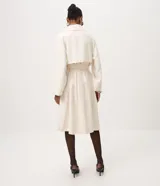Trench coat Cortelle de gabardina de viscosa color beige, con diseño largo, mangas largas, cuello alto con solapas y cierre cruzado con botones carey. Incluye tira para anudar en la cintura y bolsillos laterales.