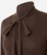 Suéter de punto color marrón chocolate, con mangas largas y diseño de cuello con recorte central y lazo ajustable.