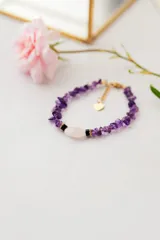 Pulsera con piedras naturales violetas y detalles en acero quirúrgico con baño de oro.