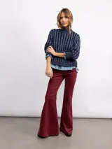 Pantalón oxford de micropana con spandex, de tiro alto y corte ajustado en la parte superior con botamanga acampanada. Presenta costuras verticales decorativas en el frente y cierre invisible lateral.