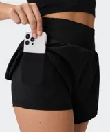Short deportivo Fabletics Sunchaser color negro, con cintura ancha de punto, short interior ajustado y pequeñas aberturas laterales en el dobladillo.