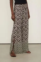 Pantalón ancho de viscosa con estampado floral en tonos oscuros, tiro medio con cintura elástica y aberturas laterales en los bajos.