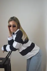 Remera estilo rugby de manga larga con cuello blanco y rayas horizontales negras y blancas.