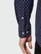 Camisa de vestir azul marino con estampado de micro figuras geométricas en blanco, de corte slim fit, cuello italiano y mangas largas con puños abotonados.