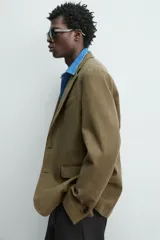 Blazer regular fit de Zara Origins, confeccionada en tejido de lana y algodón color verde militar. Presenta cuello con solapas de muesca, cierre frontal de un botón, bolsillos de solapa en la cadera y bolsillo de vivo en el pecho.