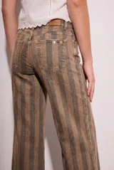 Jean de corte wide leg con diseño de rayas verticales en tonos tierra. Presenta tiro medio, cinco bolsillos y ruedo desflecado.