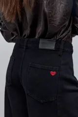 Jean wide leg negro de tiro alto, con calce amplio y pierna extra ancha, de líneas limpias.