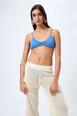 Top de bikini azul con textura fruncida y detalle de aro al frente. Posee breteles finos regulables y un calce cómodo que realza el busto con un toque moderno.